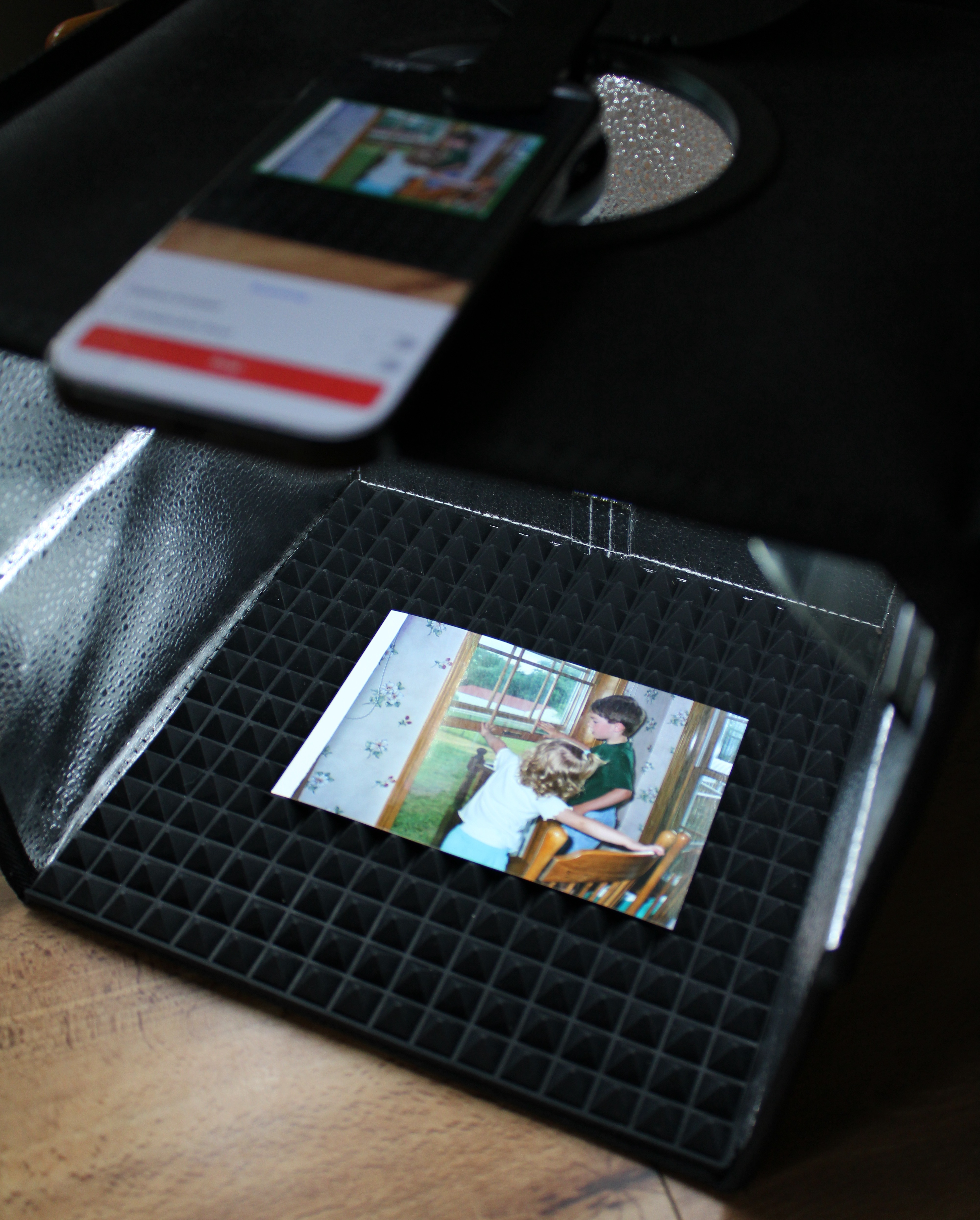 Clio photo booth with a childhood print on the scan bed, evenly lit for a glare-free capture.